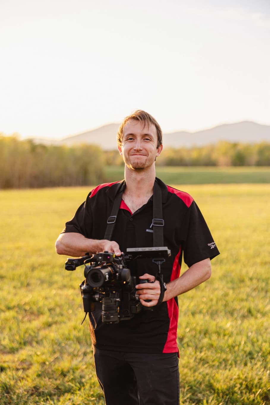 Andrew Musser holding a gimbal-mounted camera at golden hour