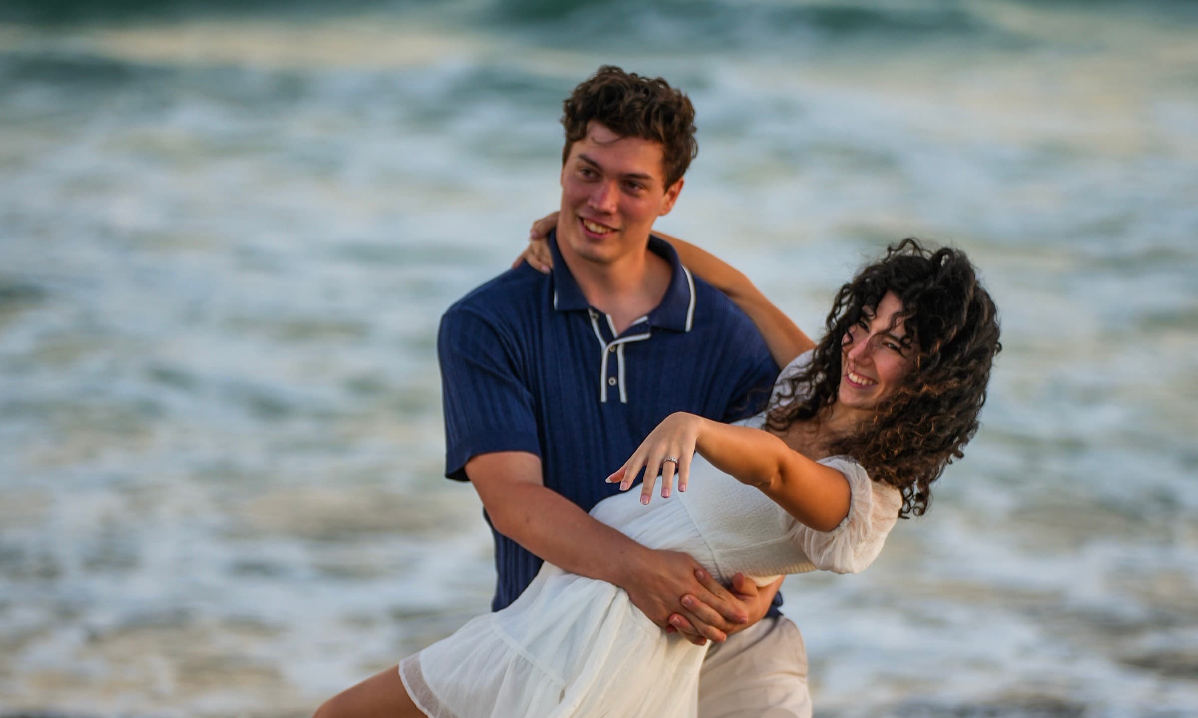 Engaged couple at the beach at sunset